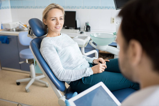 Young casual woman in chair having visit to dentist and listening carefully during consultation.  - Photo, Image