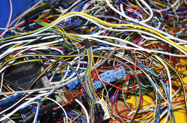  A csomó elektromos vezetékek vagy kábelek erősen kusza együtt. Vezetékek, különböző színű, rakott egy nagy halom maradványai. A vezetékek vannak tömörített hüvelyek-kapcsolat. - Fotó, kép