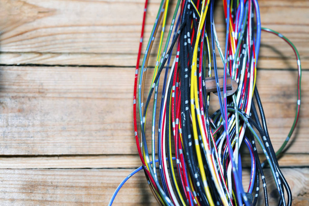  Les fils ou câbles électriques sont fortement enchevêtrés. Des restes de fils de différentes couleurs, empilés dans une grosse pile. Sur les fils, il y a des ferrules compressés pour la connexion
. - Photo, image