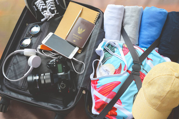 багаж с одеждой и аксессуарами, упаковка и подготовка к отъезду, путешествие и отдых концепции
 - Фото, изображение