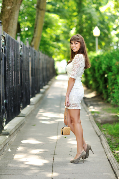 Full length portrait of a beautiful woman in white dress walking - Фото, изображение