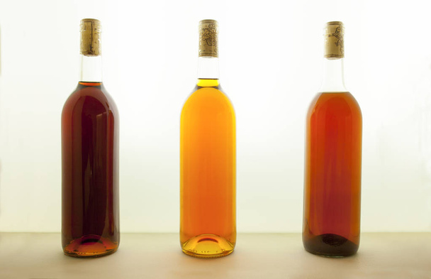Sarımsı kahverengi ile farklı tonları şarap üç şişe. Şarap renk kavramı - Fotoğraf, Görsel