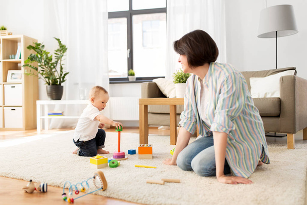 счастливая мать с маленьким мальчиком, играющим дома
 - Фото, изображение