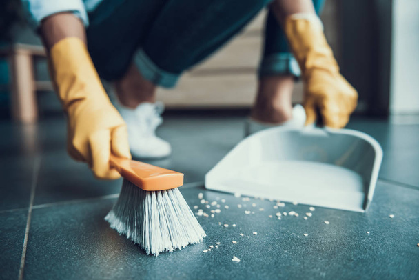 Young Woman in Gloves Sweeping Floor with Brush - Foto, Imagen
