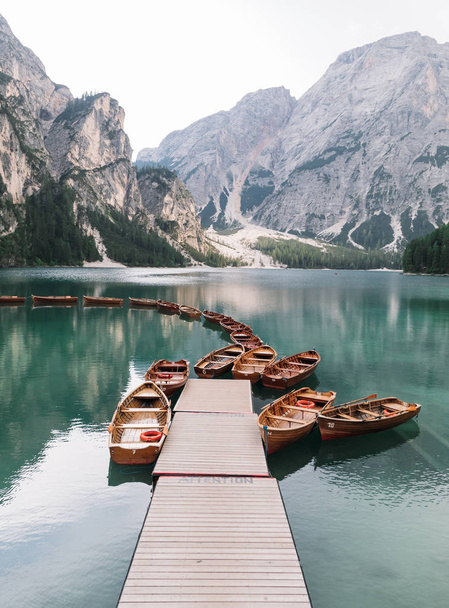majestic view of pier with wooden boats at beautiful lake in mountains, Lago di Braies, Italy - Valokuva, kuva