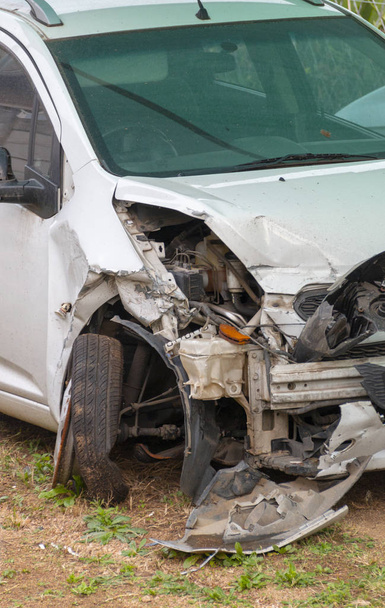 Una piccola auto bianca che ha avuto un grave incidente, c'è un sacco di danni sul lato anteriore sinistro di esso
 - Foto, immagini