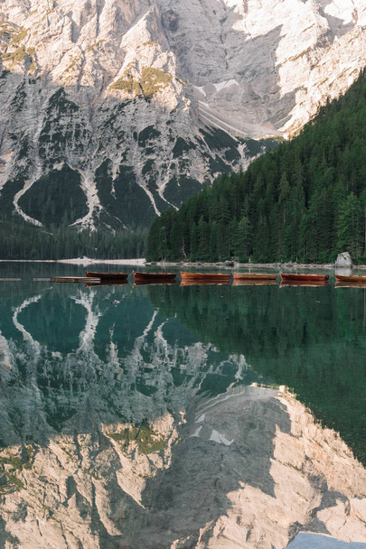 majestic view of pier with wooden boats at beautiful lake in mountains, Lago di Braies, Italy - Φωτογραφία, εικόνα