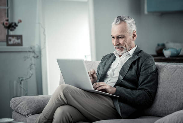 Delighted mature businessman looking at computer - Photo, image