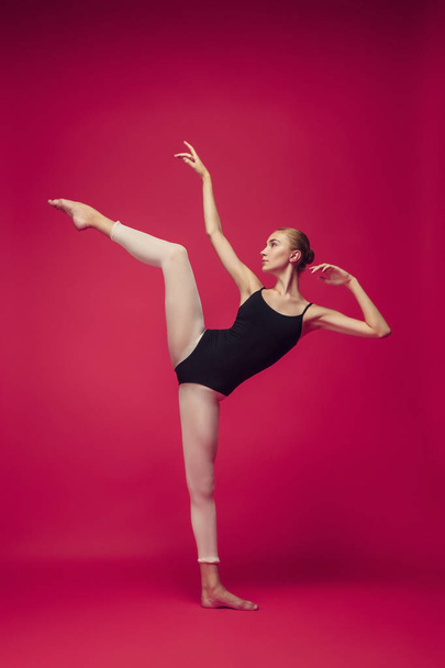 Young teen dancer on red studio background. - Foto, afbeelding