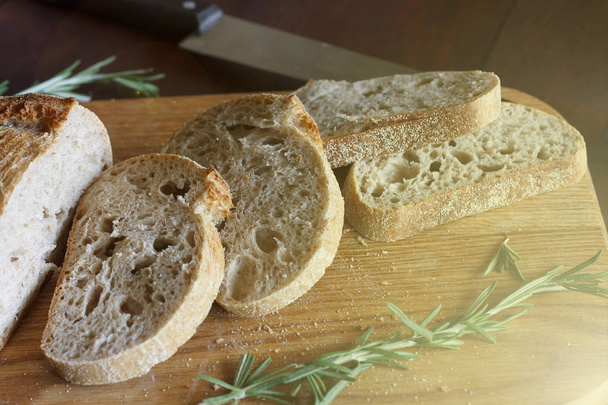 Szeletelt kenyér egy vágódeszka. Ciabatta. Egészséges táplálkozás - Fotó, kép