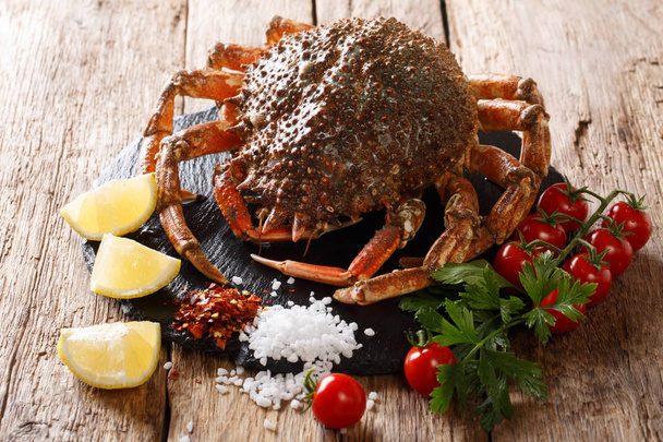 Fondo de mariscos: cangrejo araña comestible crudo con ingredientes de cerca en una tabla de piedra sobre una mesa de madera. horizonta
 - Foto, Imagen
