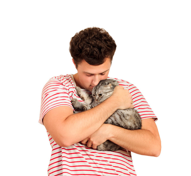 A cat and a man, a portrait of a happy cat with close eyes and a young man, people playing with a kitten. The guy hugs his pet. emotional man isolated on white background. - Фото, зображення