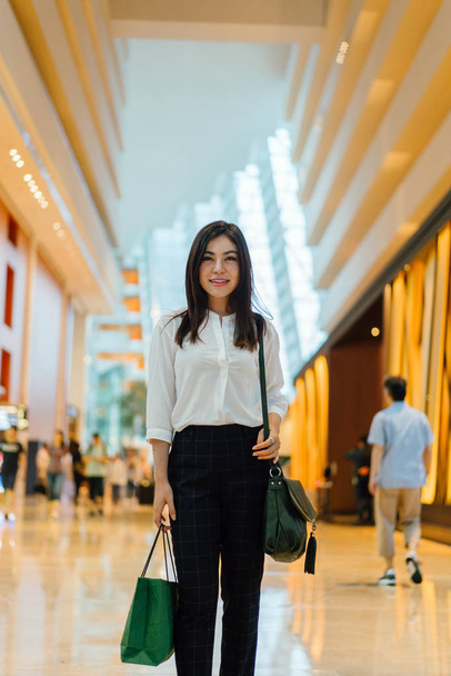 Young attractive asian woman with shopping bag in the mall  - Фото, зображення