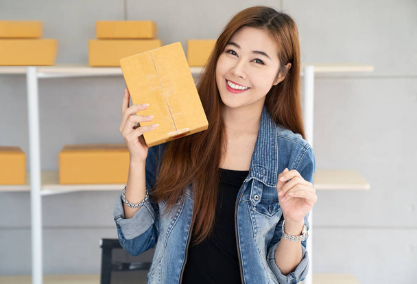 Pienyrityksen omistaja, aasialainen nainen pidä paketti laatikko, online-markkinoinnin pakkauslaatikot ja toimitus, pk-yrityksen käsite. Nuoret omistajat ihmiset aloittavat yrityksen verkossa
 - Valokuva, kuva