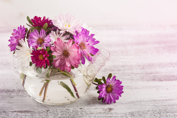 Pink purple garden flowers in pot on wooden backgrounds - Фото, зображення