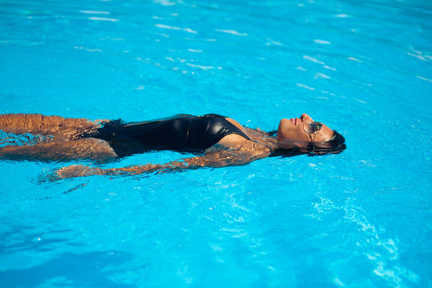 Elegante donna sexy in bikini sul corpo esile e tornito abbronzato posa vicino alla piscina
 - Foto, immagini