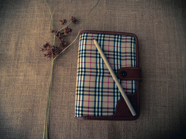Vintage tarzı. Kapalı günlüğü, Kuru ot, kalem ve çuval bezi arka plan ile organize masası - Fotoğraf, Görsel