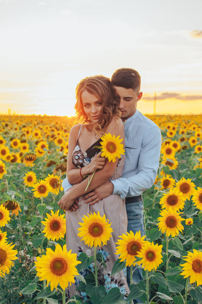 Beautiful couple having fun in sunflowers fields - Foto, Imagen