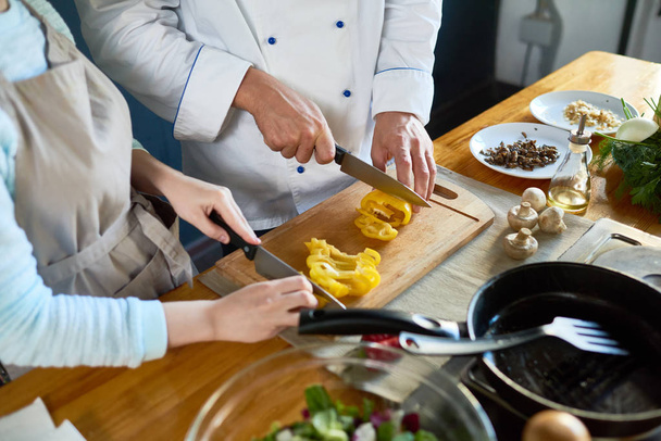 Primer plano del chef y su asistente preparando ensalada juntos
 - Foto, Imagen