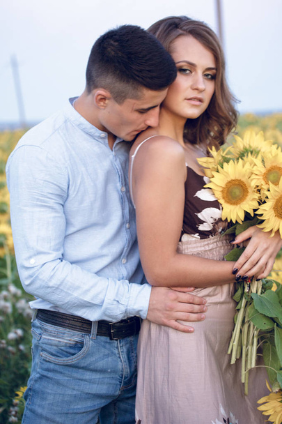 smiling young couple with sunflowers funy and love - Zdjęcie, obraz