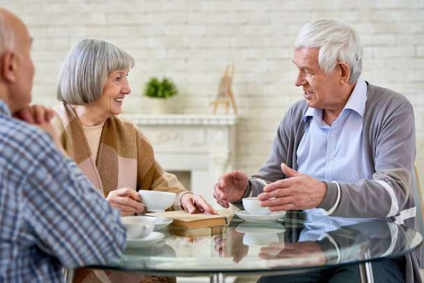 Groupe de personnes âgées bavardant et buvant du thé profitant du temps passé à la maison de retraite, espace de copie
 - Photo, image