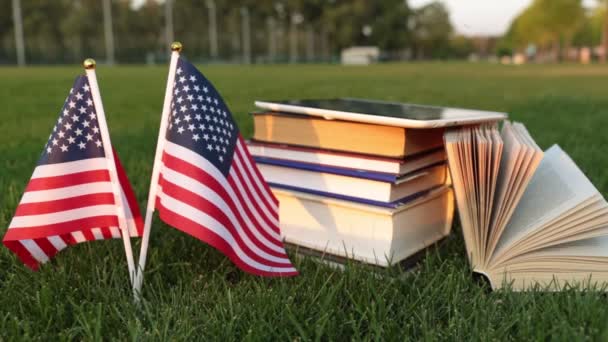 Βιβλία και την αμερικανική σημαία στο γρασίδι. Σπουδές στην Αμερική. - Πλάνα, βίντεο