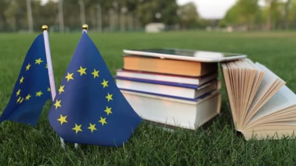 σημαία της Ευρωπαϊκής Ένωσης και βιβλία στο γρασίδι. Εκπαίδευση στην Ευρώπη. - Πλάνα, βίντεο