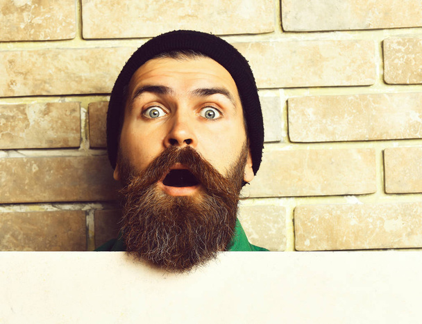 Bearded brutal caucasian hipster with white paper sheet - Foto, imagen