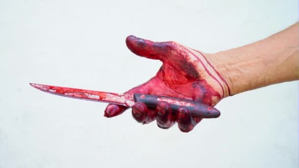 Ruce a nůž v krvi na bílém pozadí, mužské ruky s krvavý nůž - Záběry, video