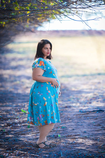 Беременная женщина на открытом воздухе - Держит живот
 - Фото, изображение