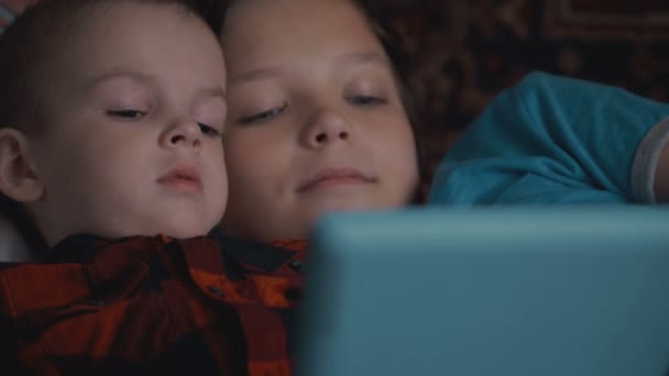 Twee jongens beelden met behulp van tablet pc liggend op de Bank - Video