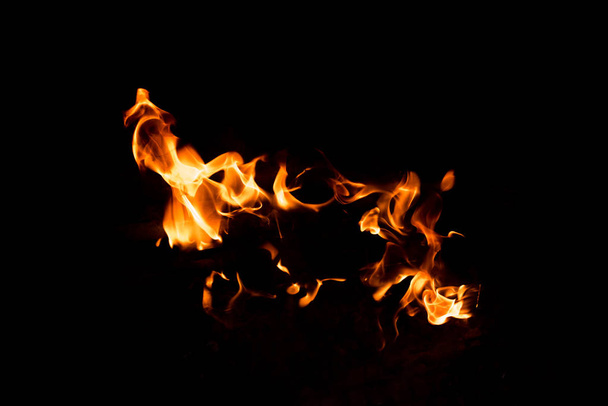 Φλόγες στη φωτιά από ένα κόκκινο και κίτρινο μπάρμπεκιου. - Φωτογραφία, εικόνα