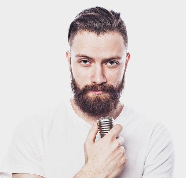 lifestyle and people concept: young bearded man singing with microphone - Фото, изображение