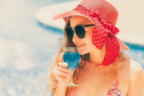 Szczęśliwa młoda kobieta na sobie strój kąpielowy o dobry czas w basenie w luxury resort. Letnie podróże wakacje koncepcja. - Zdjęcie, obraz