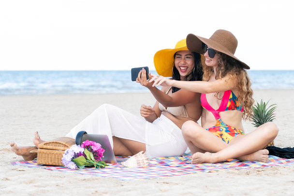 Щасливі жінки в бікіні фотографують селфі з мобільного телефону разом на тропічному піщаному пляжі влітку. Подорожі стиль життя
. - Фото, зображення