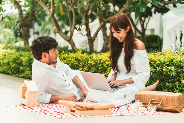 Feliz pareja joven ir de picnic y citas en el parque en verano
. - Foto, Imagen