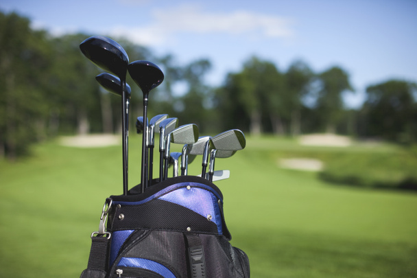 Golf bag and clubs against defocused course background - Fotografie, Obrázek