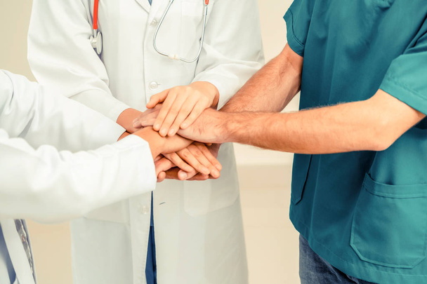 Trabajo en equipo del servicio médico: el médico, el cirujano y la enfermera unen sus manos
. - Foto, imagen