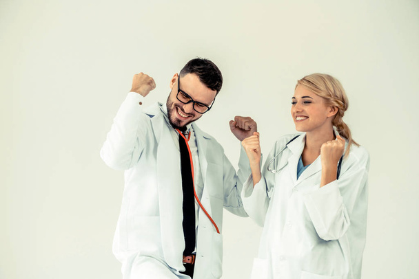 Happy successful doctor celebrates victory in hospital office with another doctor standing beside her for the success of patient treatment. - Photo, Image