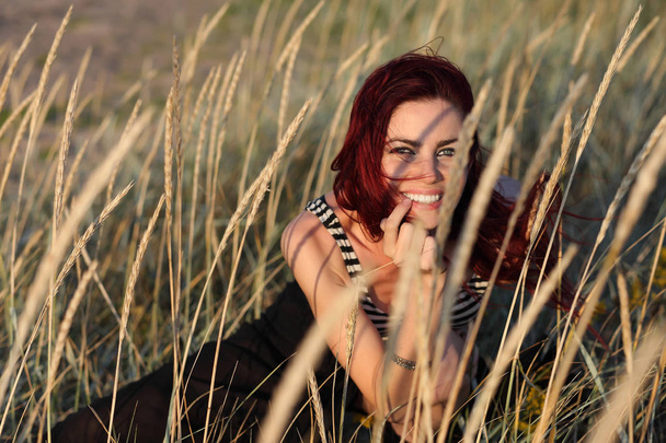 Portret młodej kobiety, ukrywa się w trawie - Zdjęcie, obraz