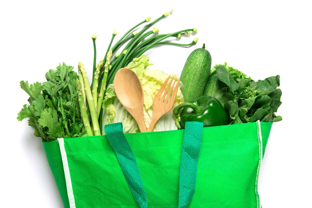 zamknąć zieloną torbę spożywczą z mieszanymi organicznymi zielonymi warzywami na białym, zdrowym ekologicznym zakupie żywności ekologicznej i dietetycznej koncepcji odżywiania opieki zdrowotnej - Zdjęcie, obraz