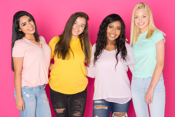 Ryhmä neljä teini tytöt hauskaa yhdessä vaaleanpunainen tausta
 - Valokuva, kuva