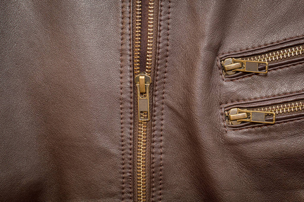 Une veste en cuir marron avec zip à moitié abaissé
 - Photo, image