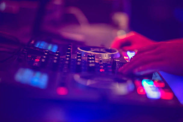 Dj mixes the track in the nightclub at party. DJ hands in motion - Foto, imagen