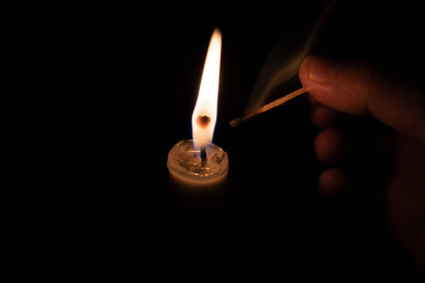 Людина запалює свічку сірниковою паличкою. гасіння сірникової стрічки
 - Фото, зображення