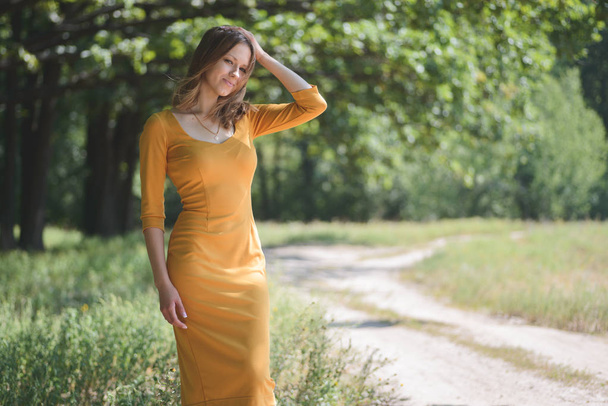 Woman in yellow dress posing outdoors  - Photo, image