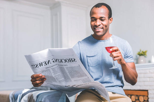 Cheerful man holding a newspaper - Foto, afbeelding