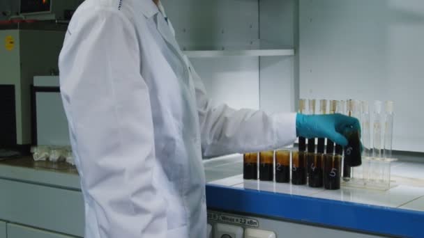 Bewegung vorbei am Laborassistenten, der Schläuche am Arbeitsplatz mit Öl füllt - Filmmaterial, Video