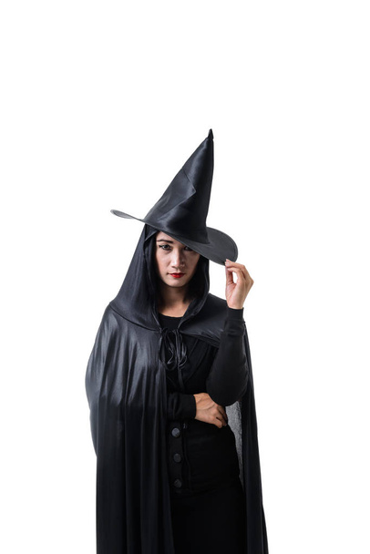 Retrato de mujer en traje de Halloween bruja miedo negro de pie Su mano atrapada en el sombrero aislado en el fondo blanco con camino de recorte
 - Foto, Imagen