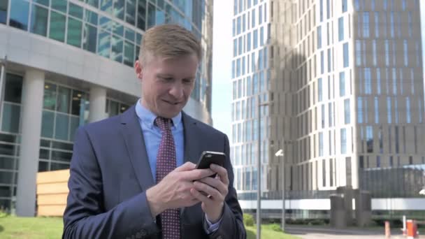 Businessman Using Smartphone Outside Office - Filmati, video